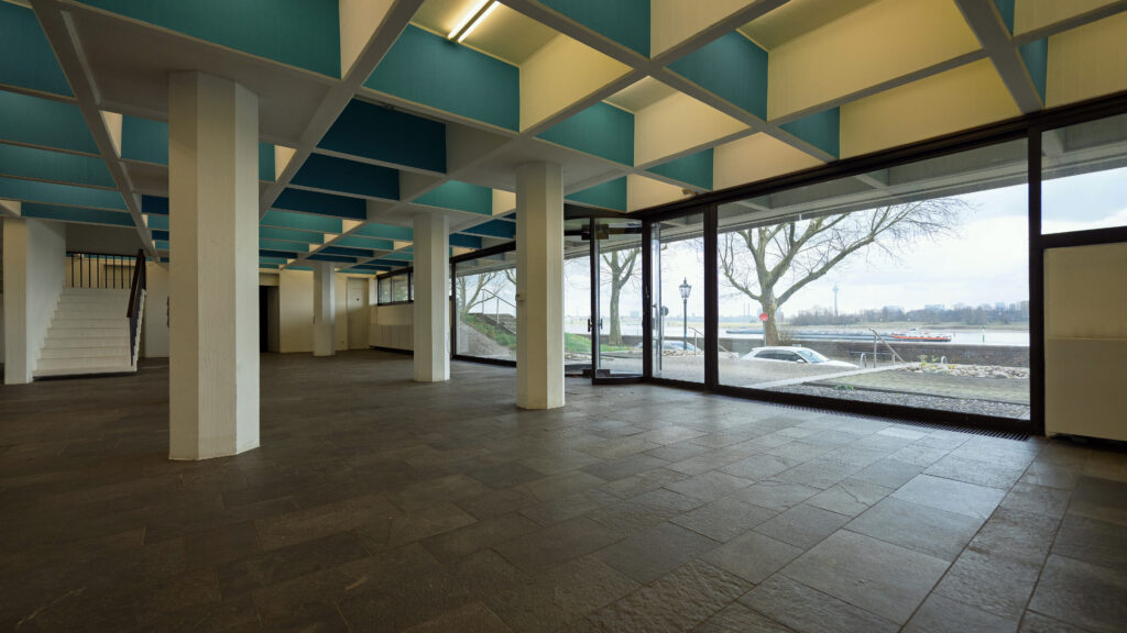 Innenraum mit Blick zur geöffneten Glasfassade, dunkler Steinboden